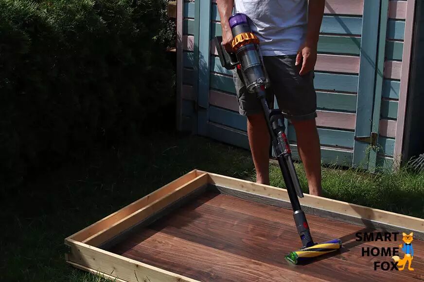 The Dyson V15 is being used in stick vacuum mode.